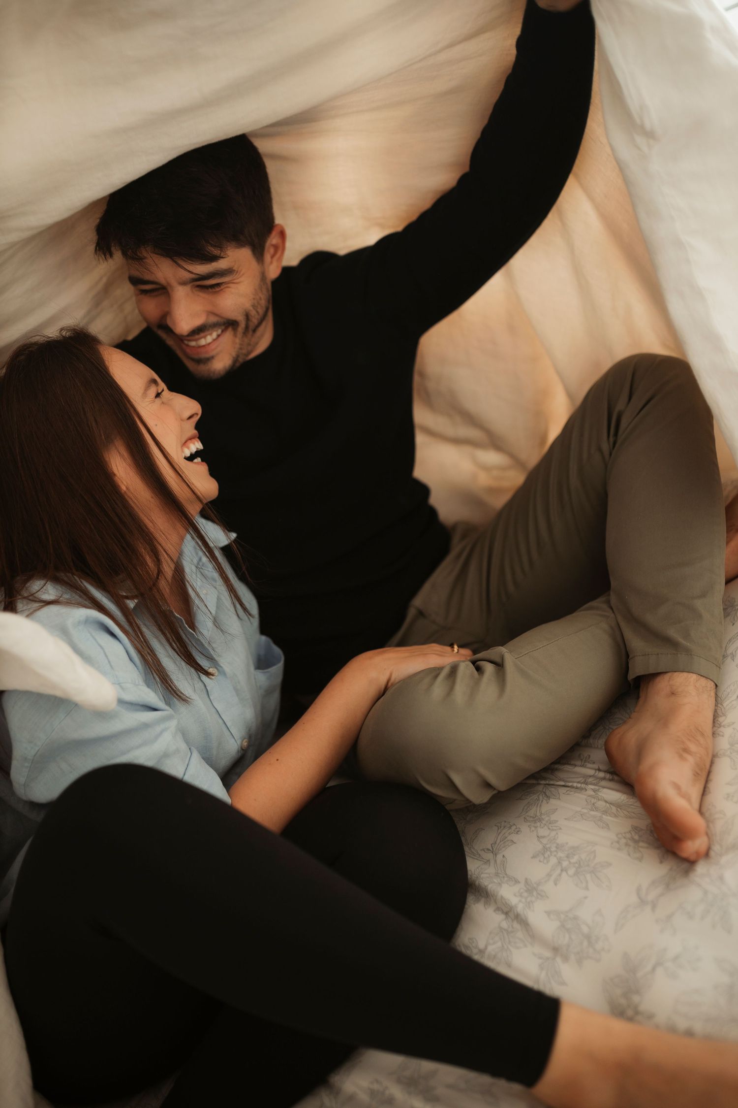 Intimate lifestyle photography showing tender moments on white bedding.