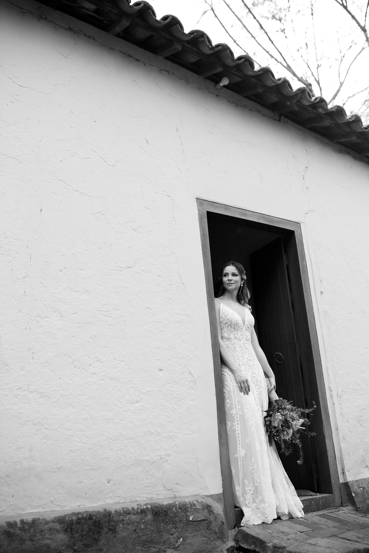 Series of black and white photos showing bride in doorway of rustic white building.