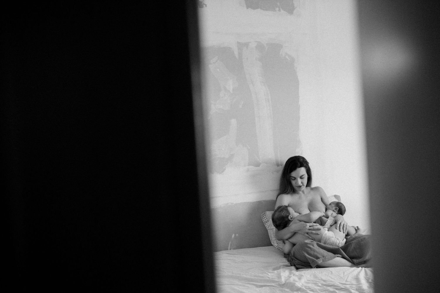 Black and white artistic series showing figures reclining in a minimalist setting.