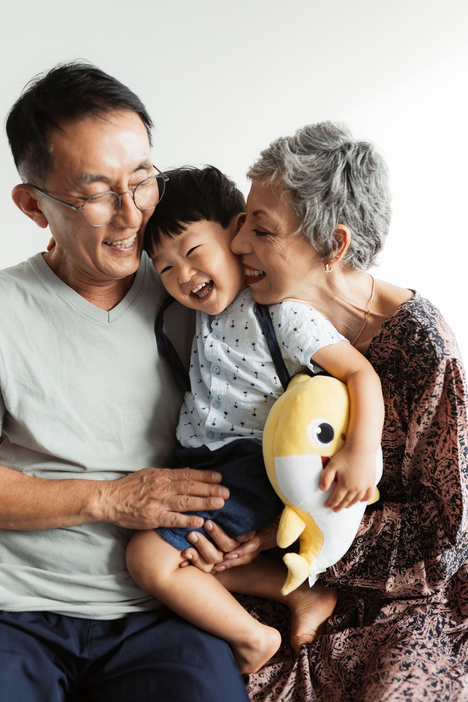 Joyful family moments captured in a series showing warm embraces and laughter with a plush toy.