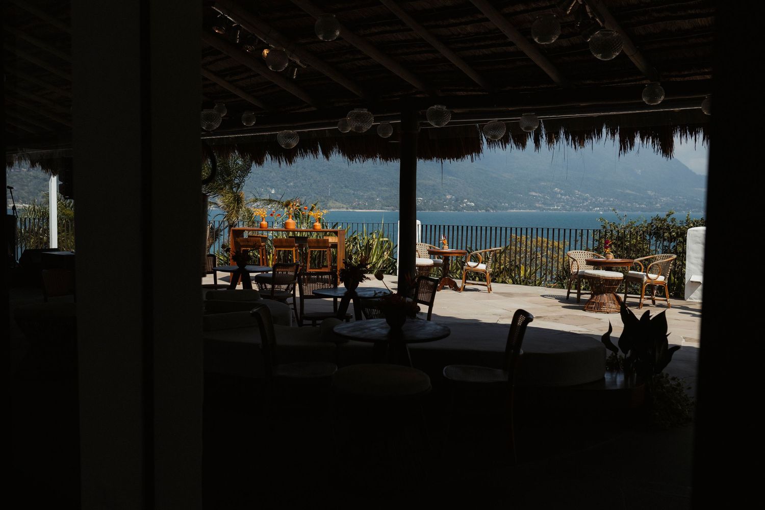 Dark silhouettes of chairs and tables against a bright outdoor setting.