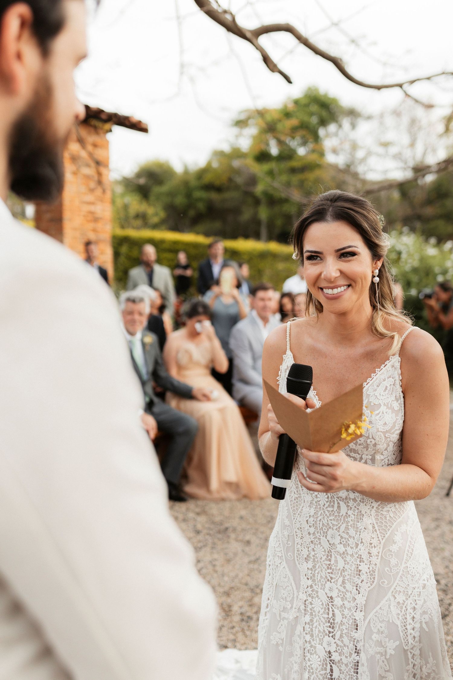 Candid wedding reactions captured under blooming tree branches.