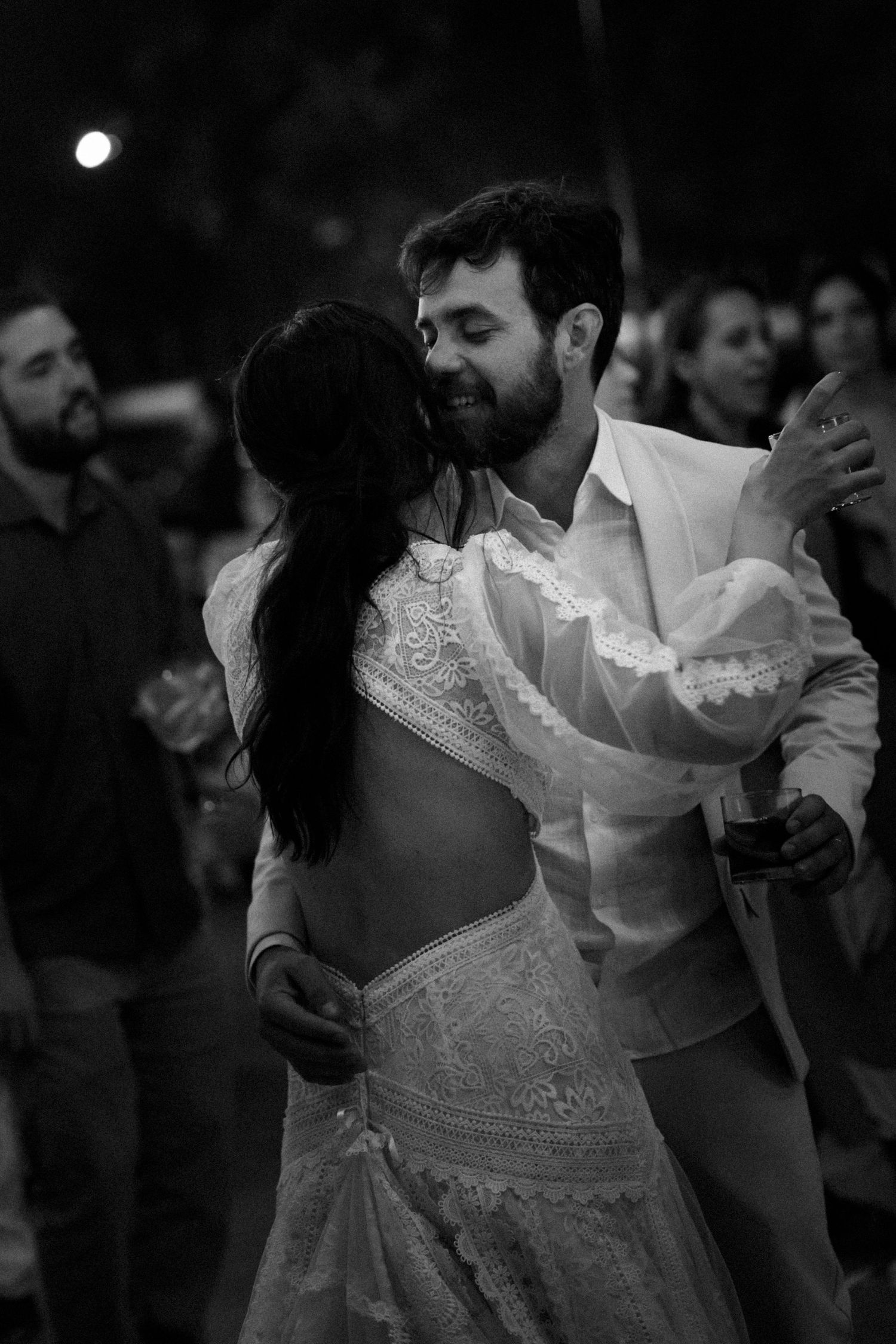Dancing couple in wedding attire captured in black and white during reception celebration.