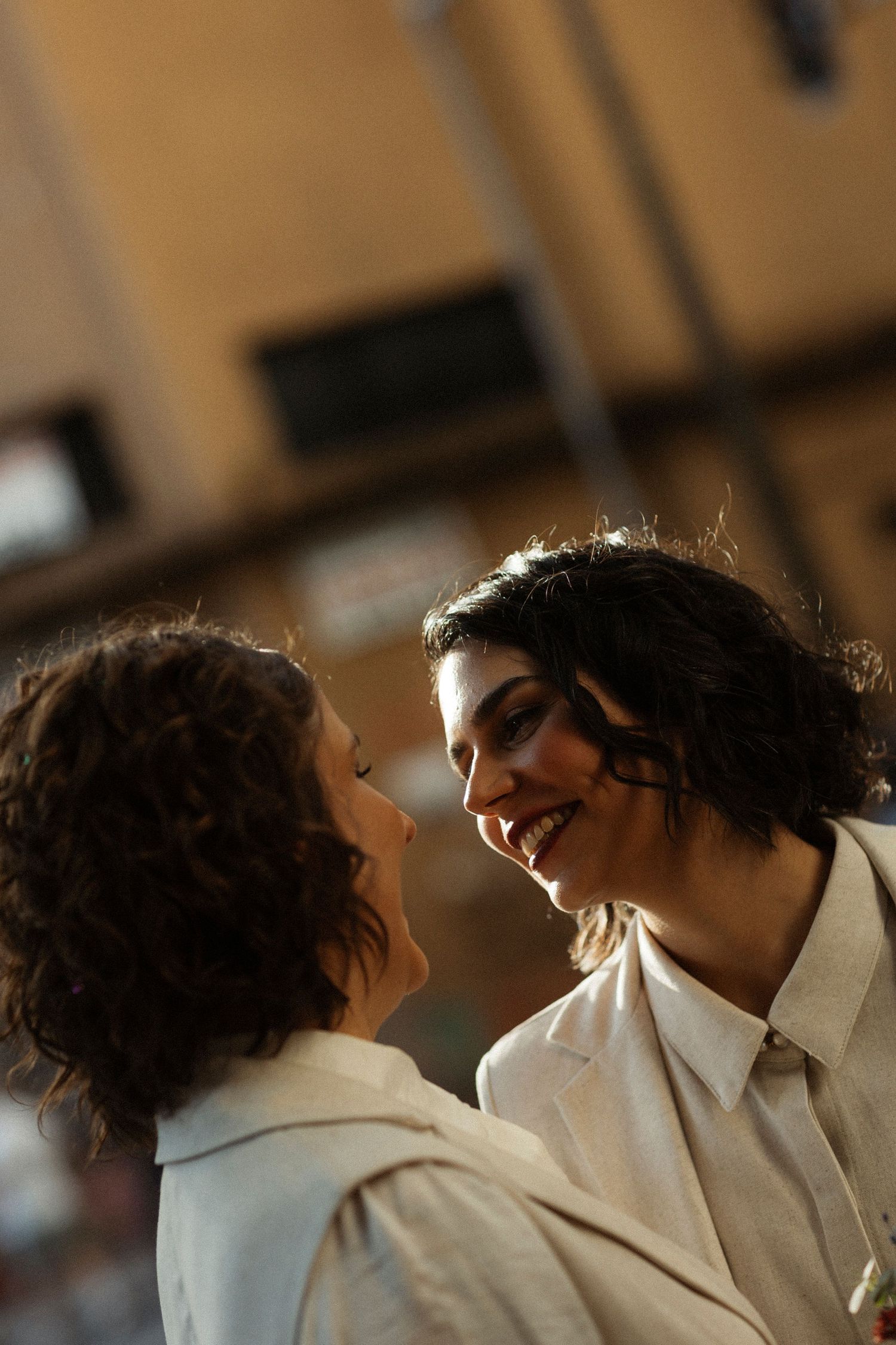 An intimate moment captured between two people in white suits sharing laughter and joy.