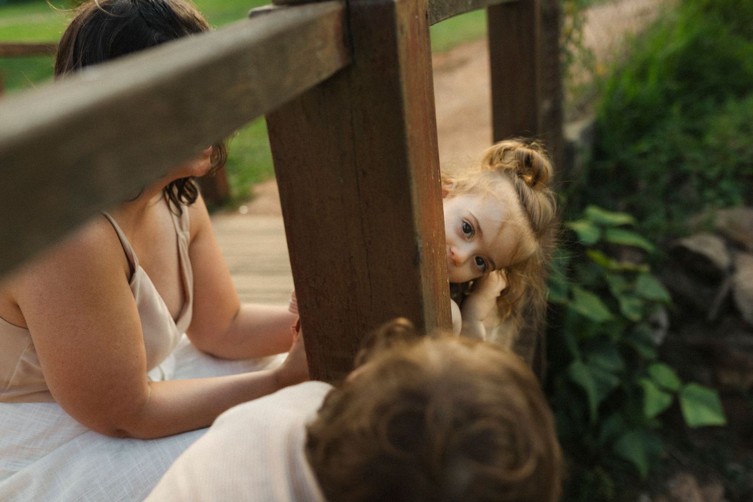Sweet interactions captured in natural outdoor setting with wooden structure in background.