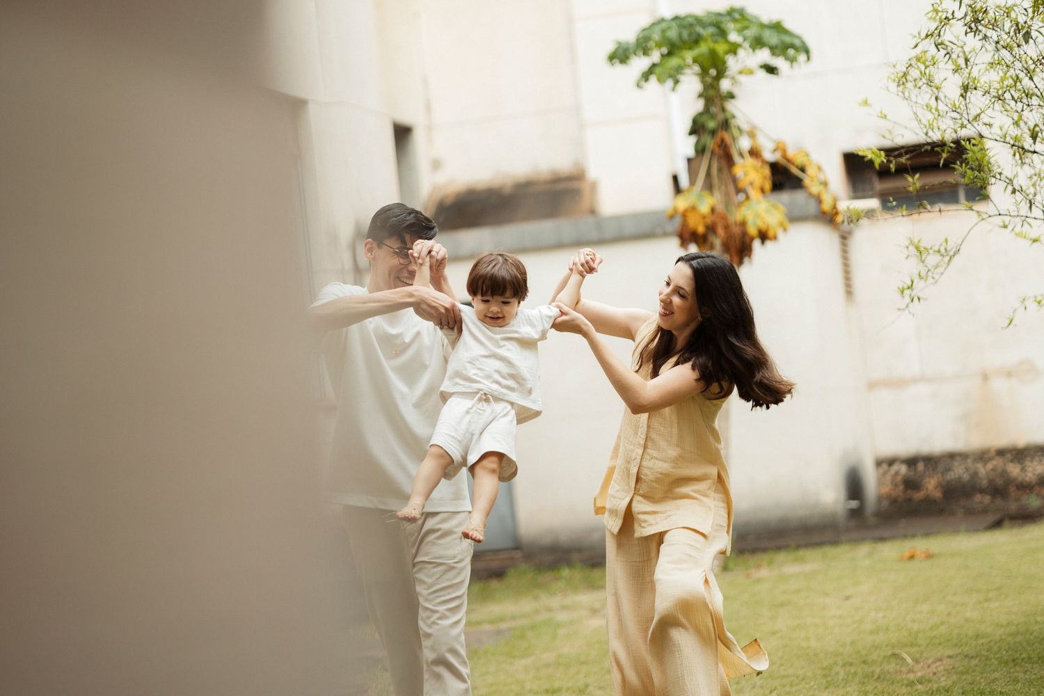 Family playing and dancing together outdoors in natural sunlight.