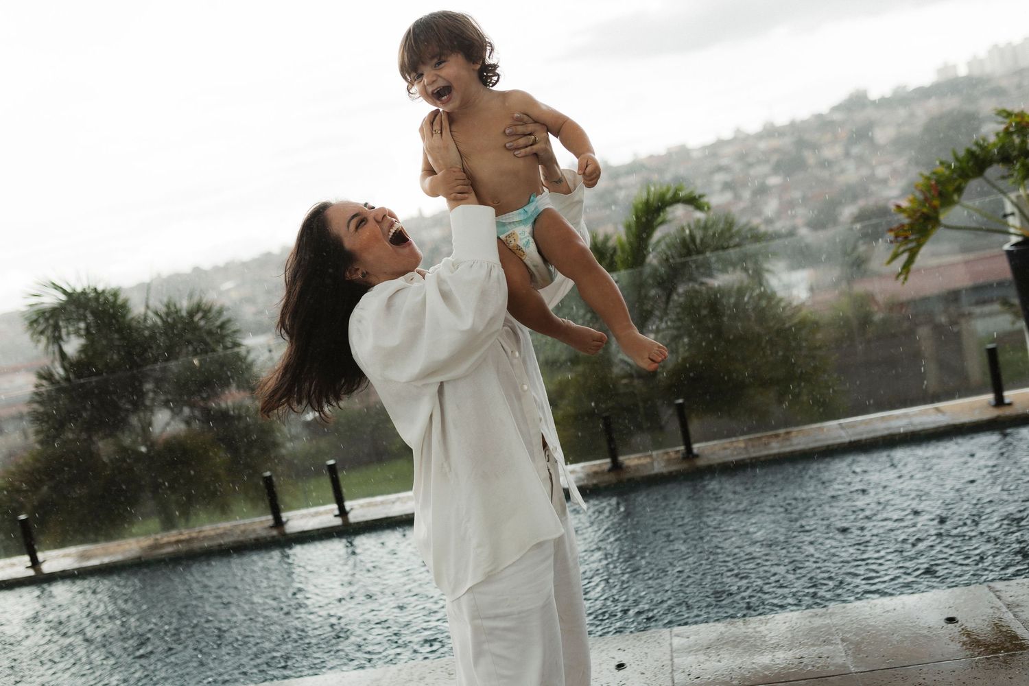 Candid moments captured by a lake with mountains in the background.