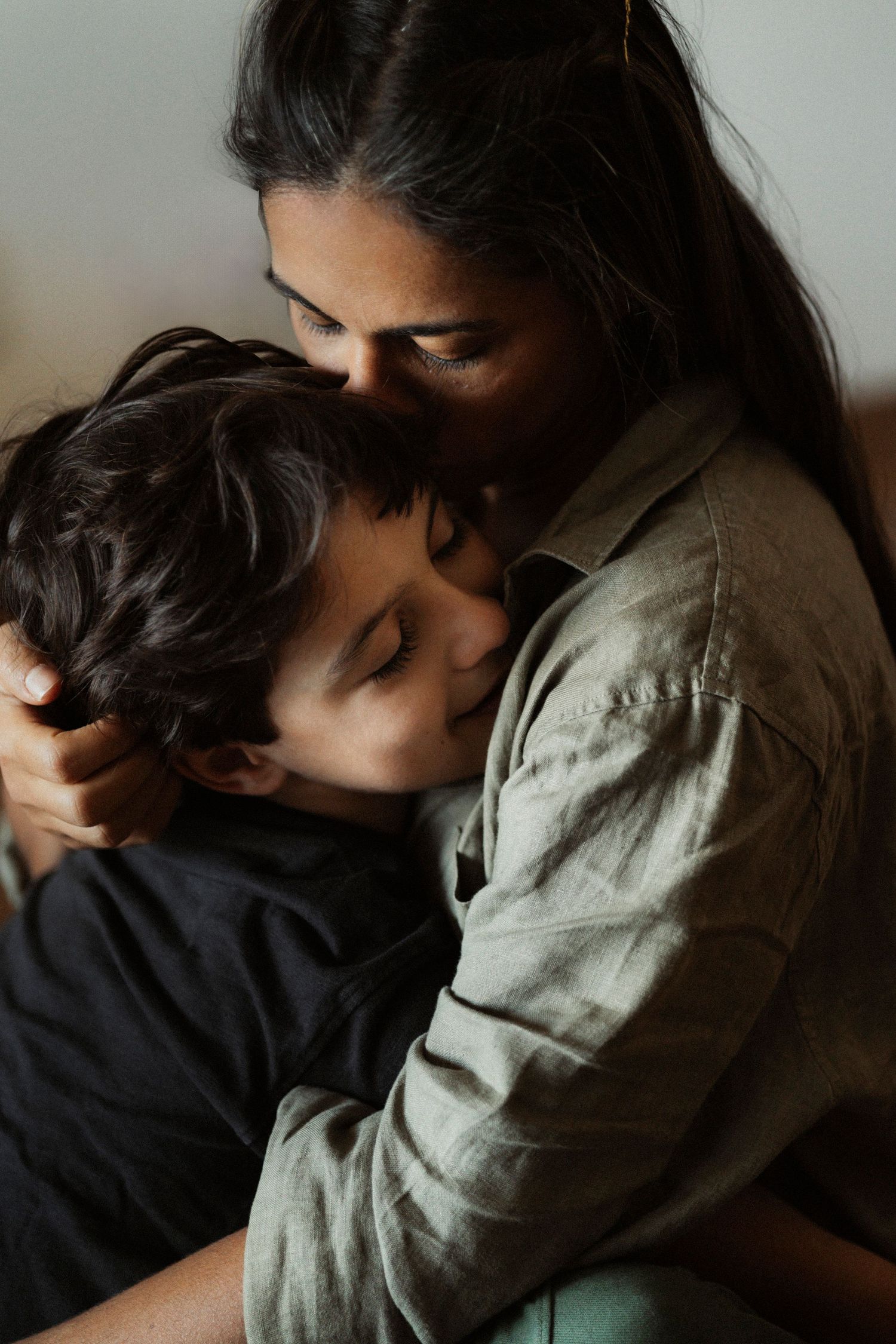 Intimate close-up shots showing tender embraces in muted lighting.