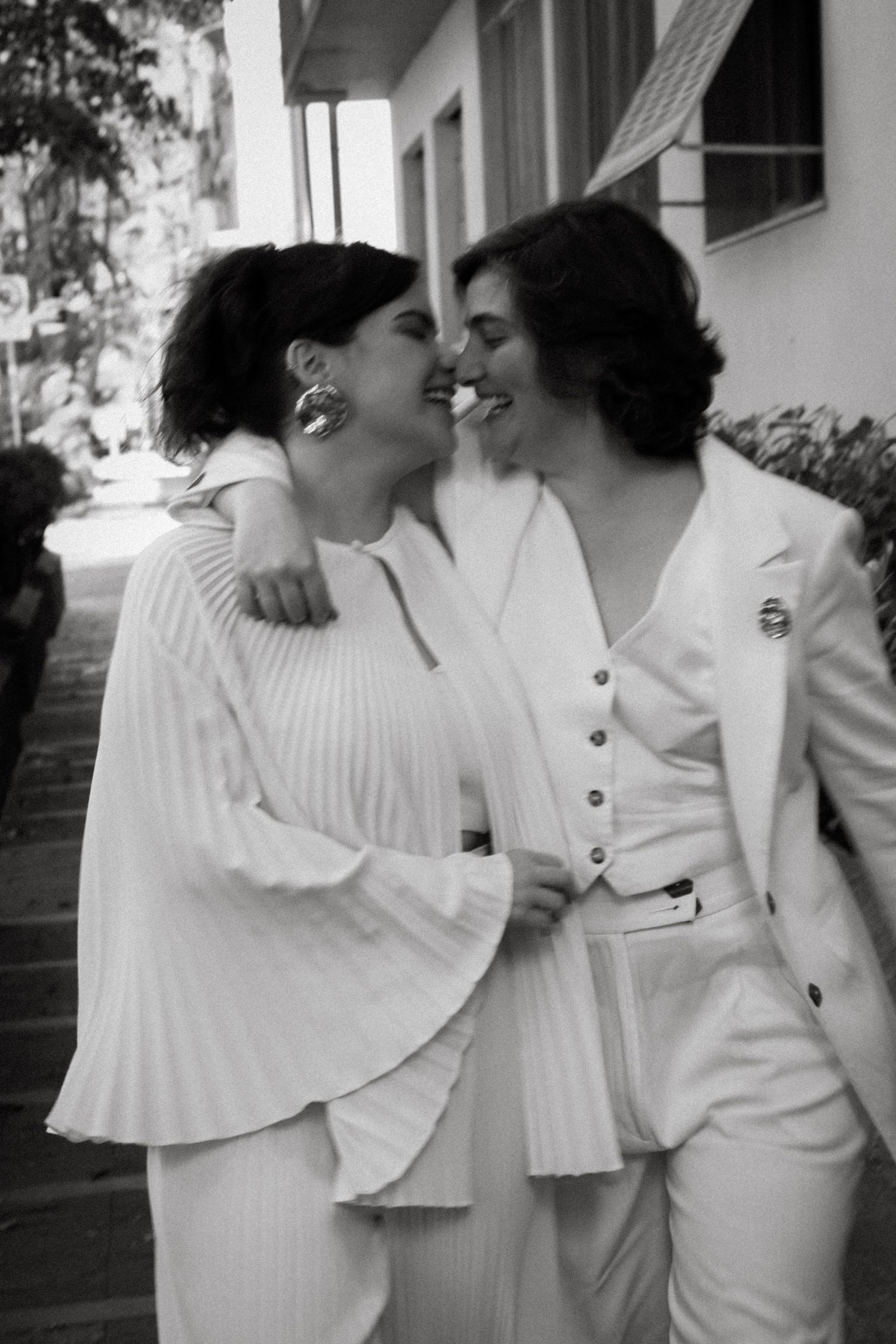 Series of intimate black and white photos showing couple in white outfits embracing on porch.