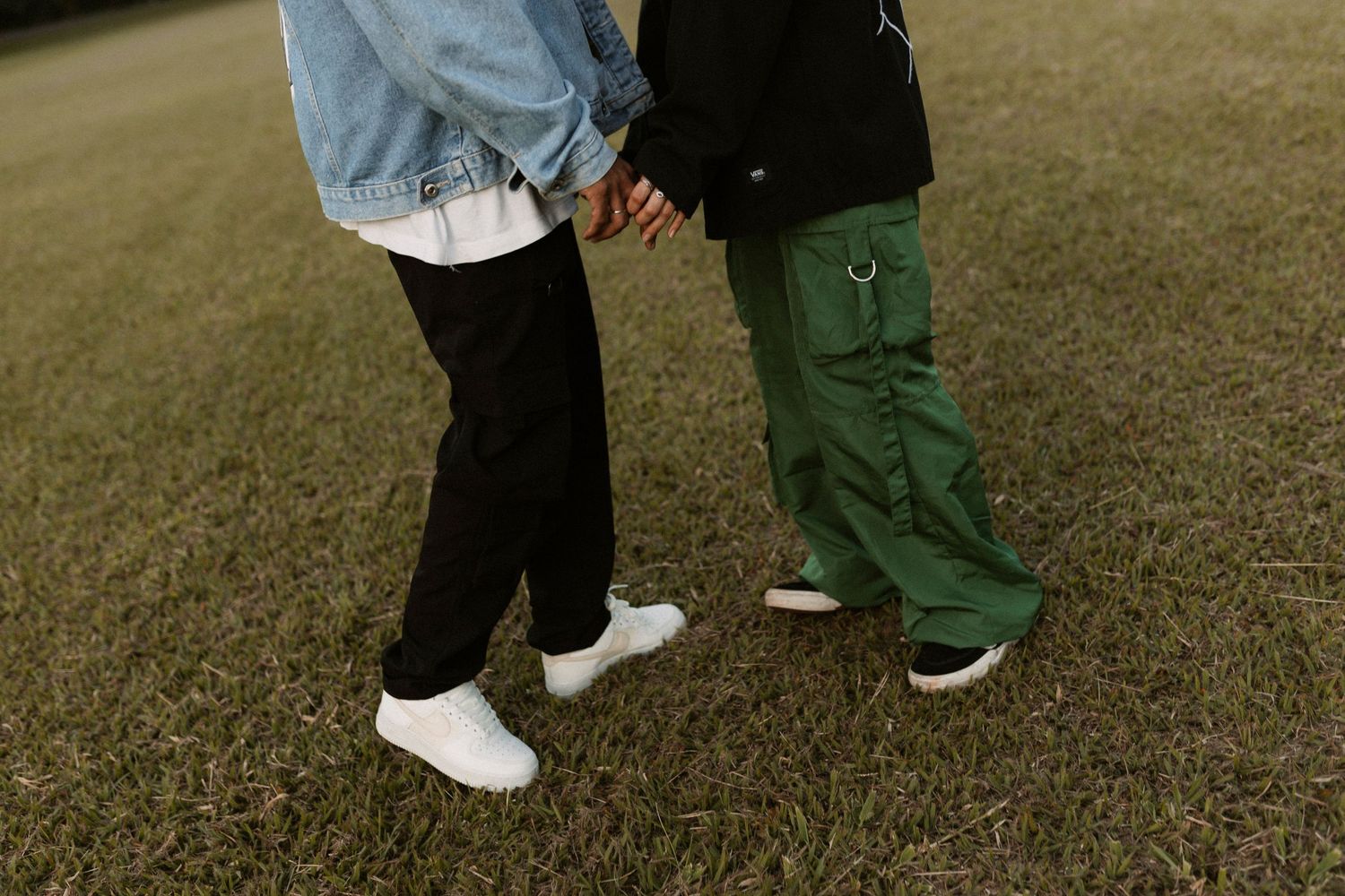 Low angle view of people walking on grass showing only their legs and feet.