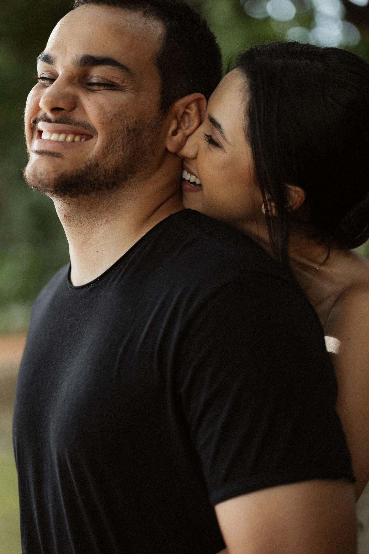 Close-up shots of a couple sharing intimate moments outdoors with natural bokeh lighting.