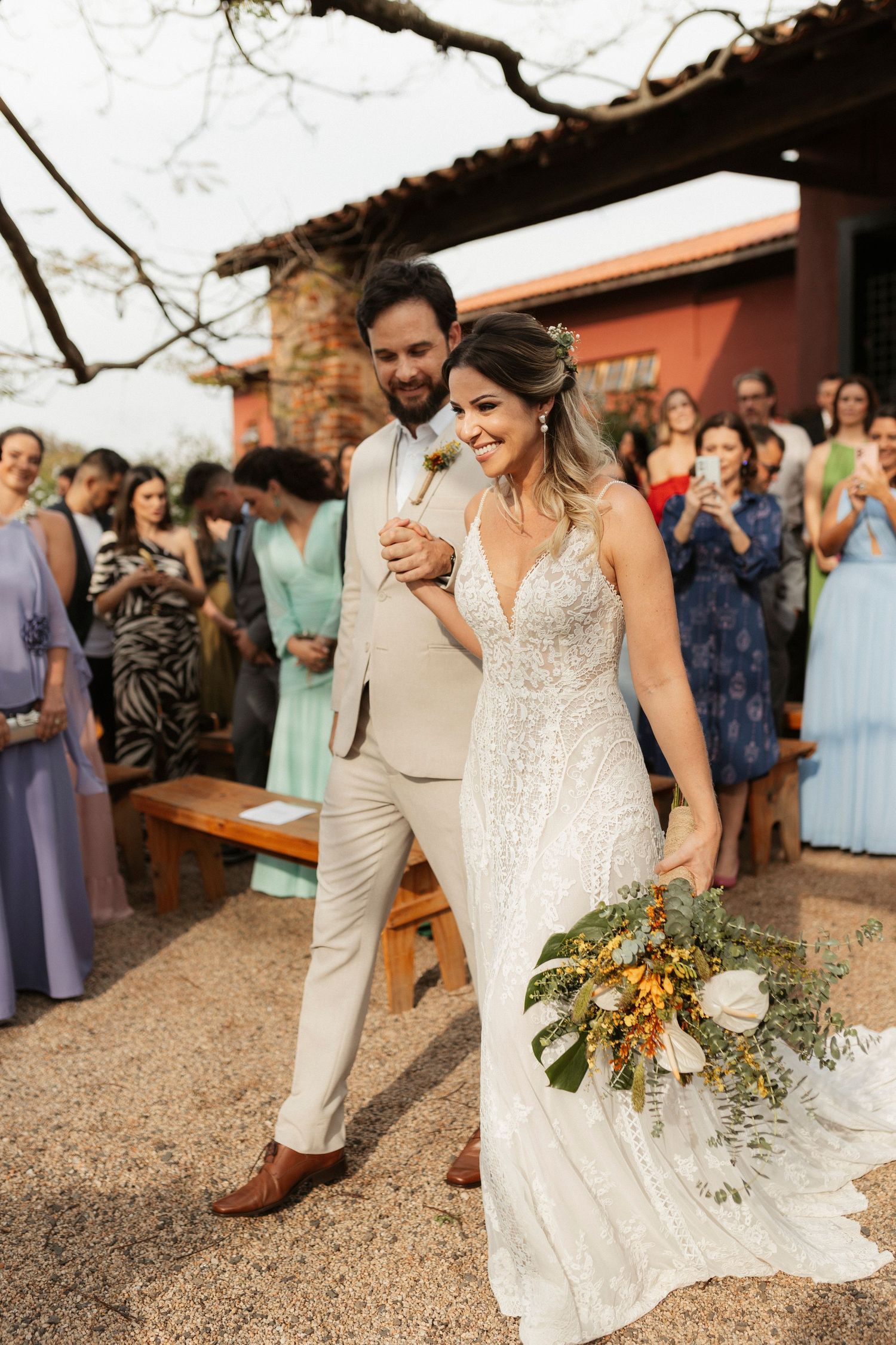 Wedding celebration with guests watching couple dance on outdoor patio.