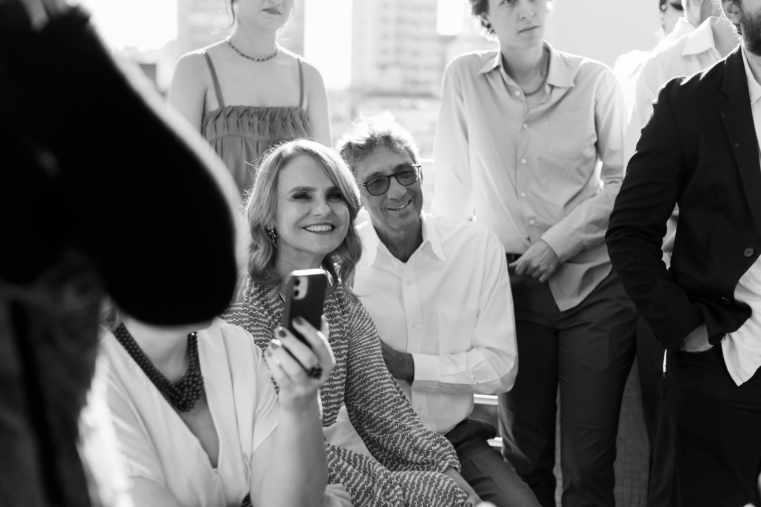 Group of people in casual attire socializing at a daytime gathering.