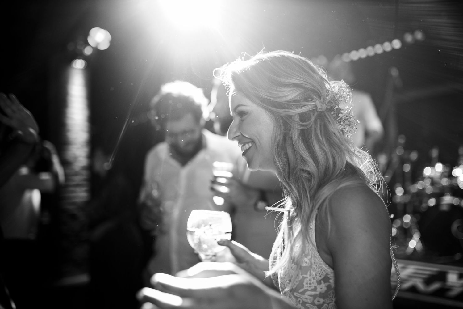 Dramatic backlit dance floor moments captured in black and white during evening celebration.
