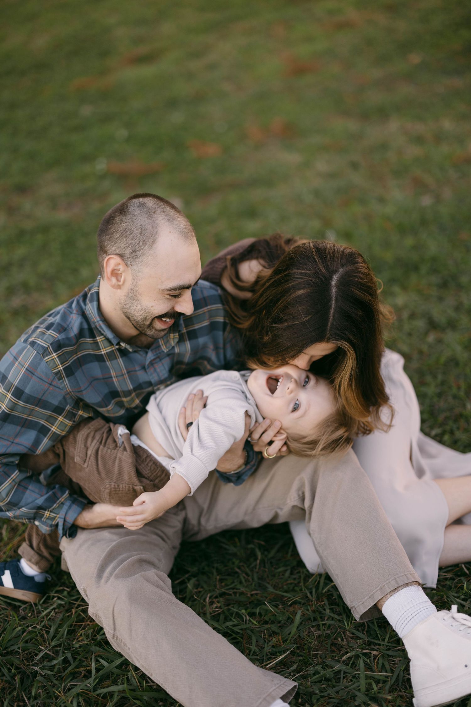 A joyful family moment captured while relaxing together on grass.