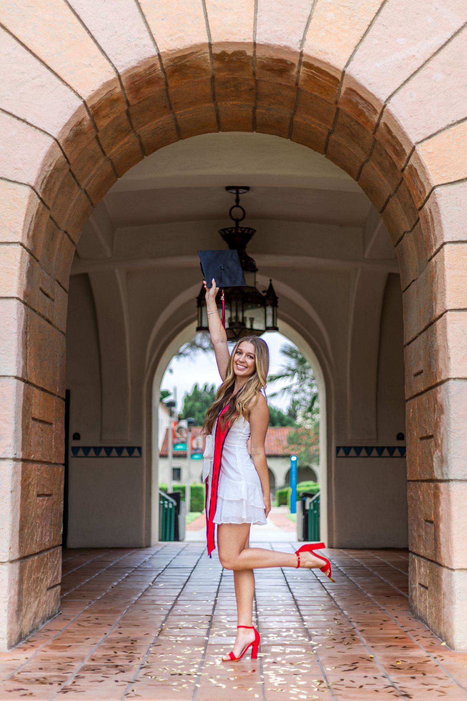 Artistic graduation photo series taken in Spanish-style archway corridor.