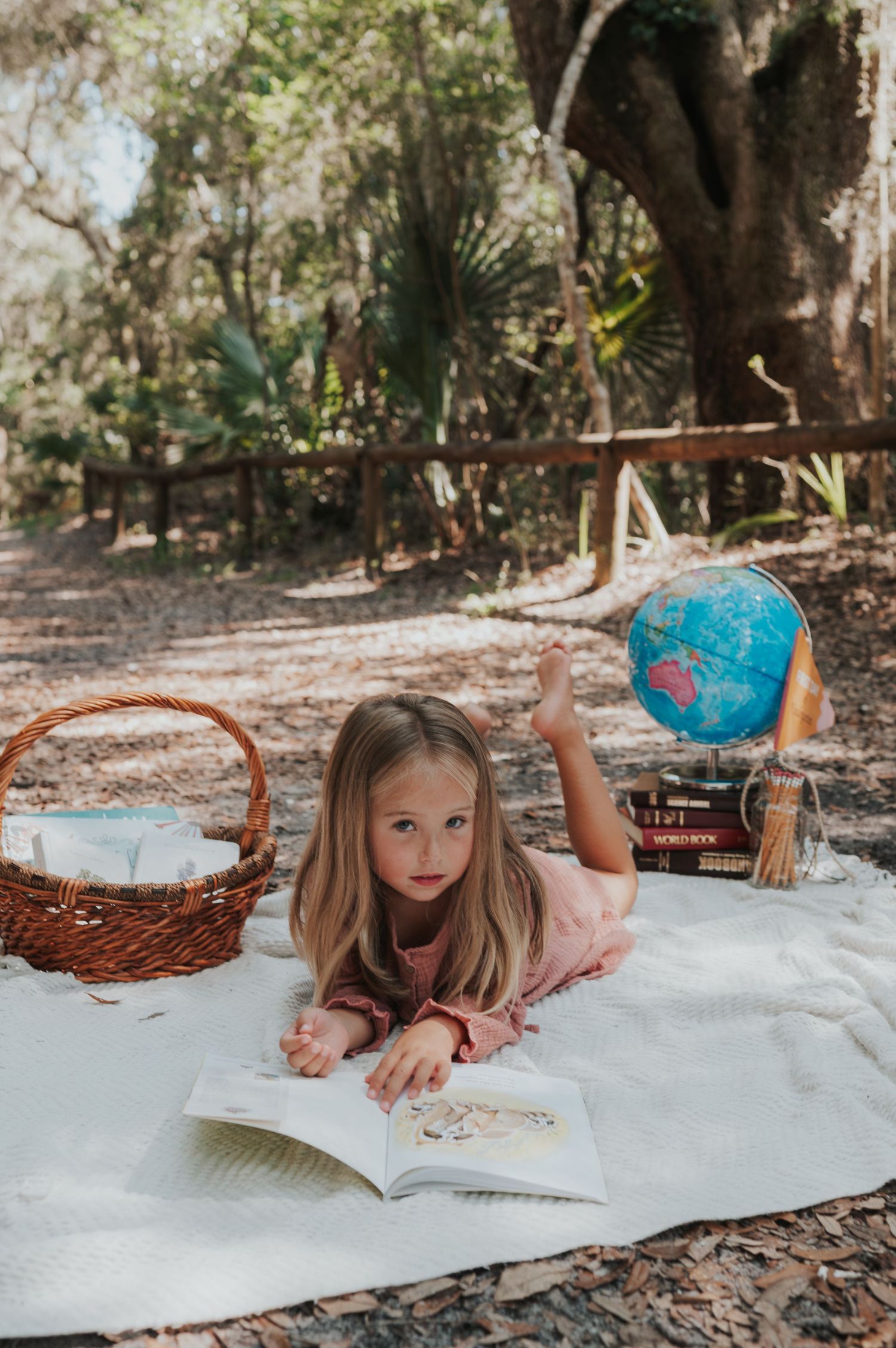 Back to school Kindergarten photograph in Amelia island Florida with a little girl reading a book and posing with a globe