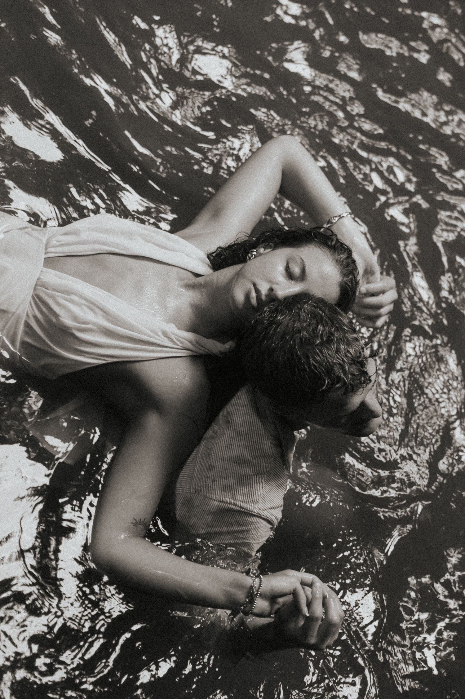Creative story telling couple embracing in the water during photography session
