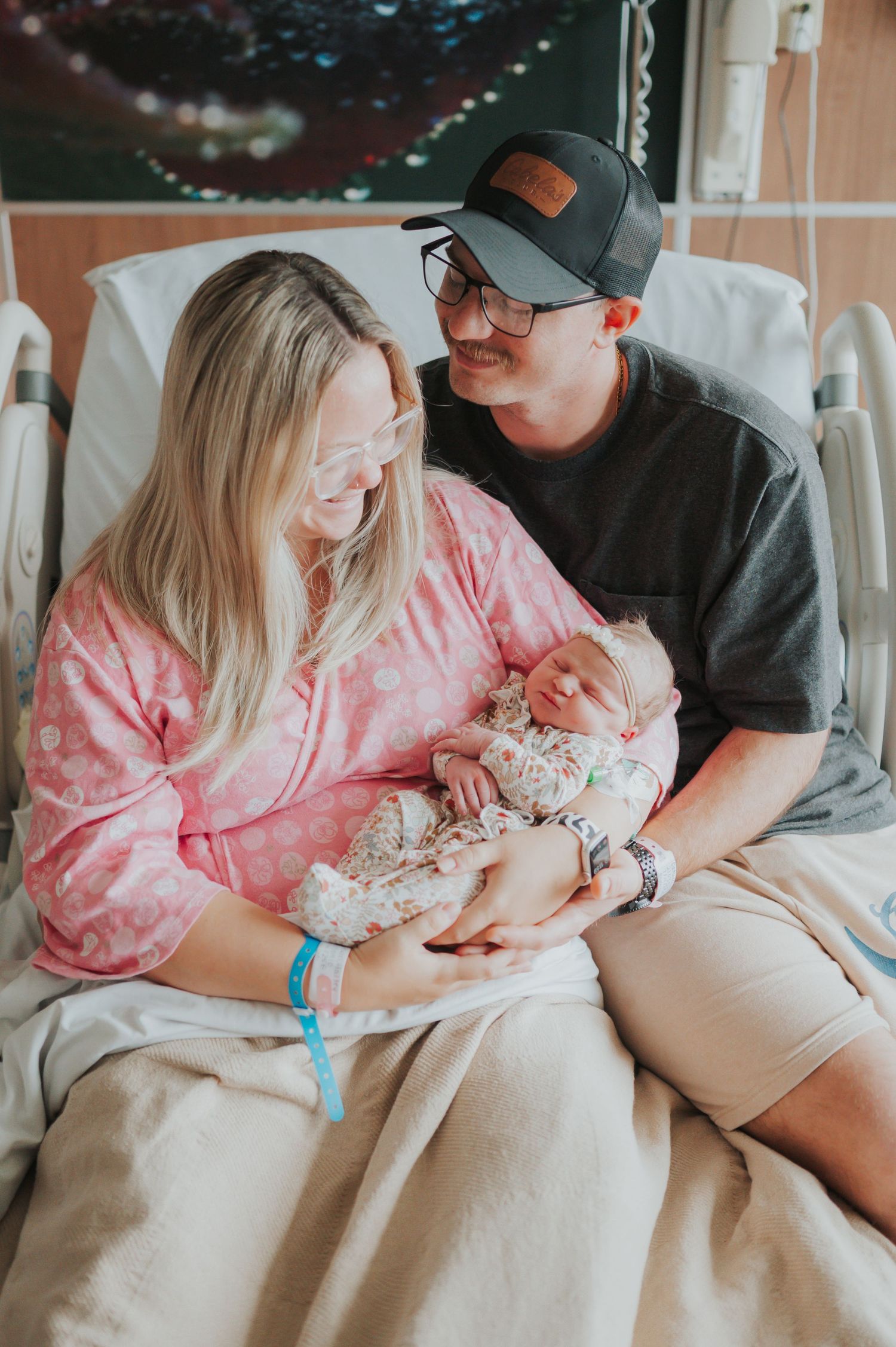 Fresh 48 photograph in hospital after giving birth of mother and father snuggling newborn infant in Jacksonville Florida