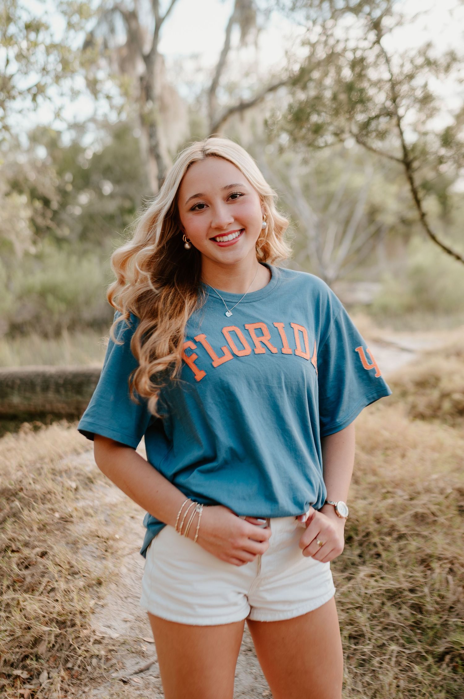 Senior girl posing at Fort Clinch in Amelia island Florida for her senior photography portrait session in a University of Florida shirt