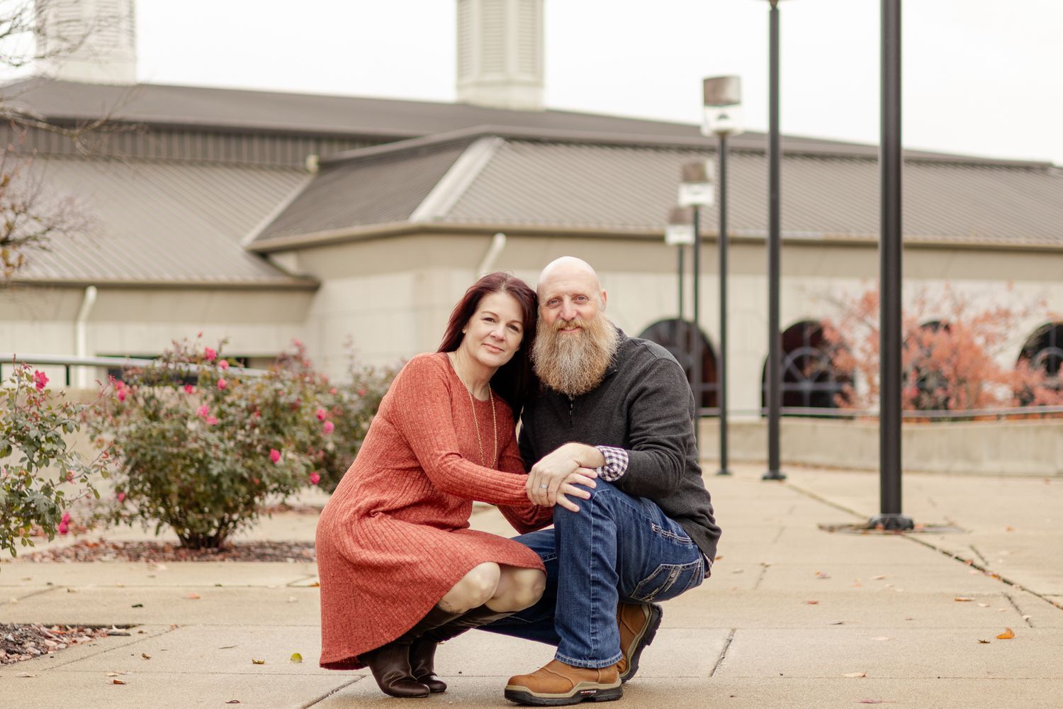 A couple sits together on concrete steps outside a building.