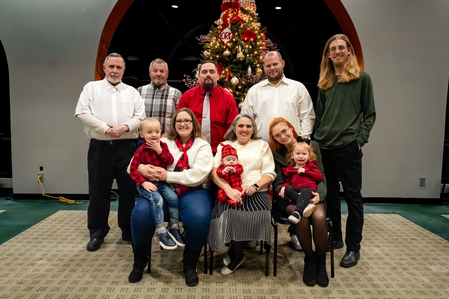 A group photo taken indoors with people sitting and standing together.