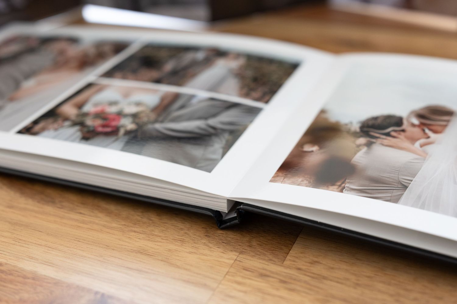 Album de photos de mariage ouvert présentant des portraits élégants sur une table en bois, mettant en valeur des tirages photographiques pr