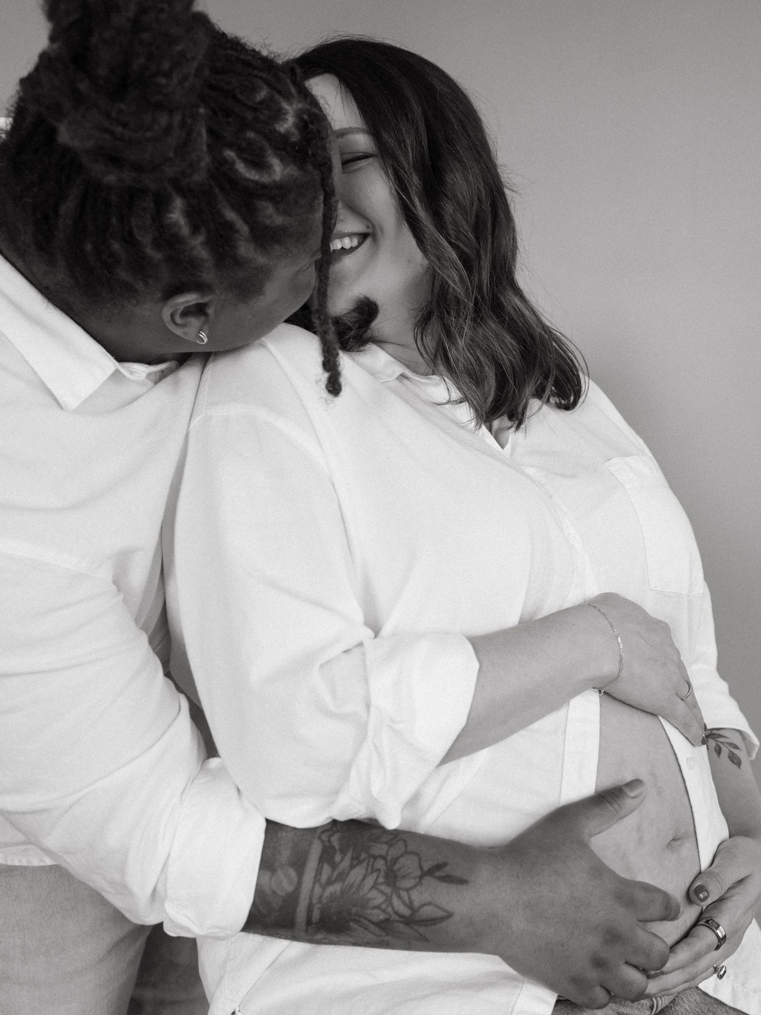 Intimate black and white portrait of couple in white shirts embracing.