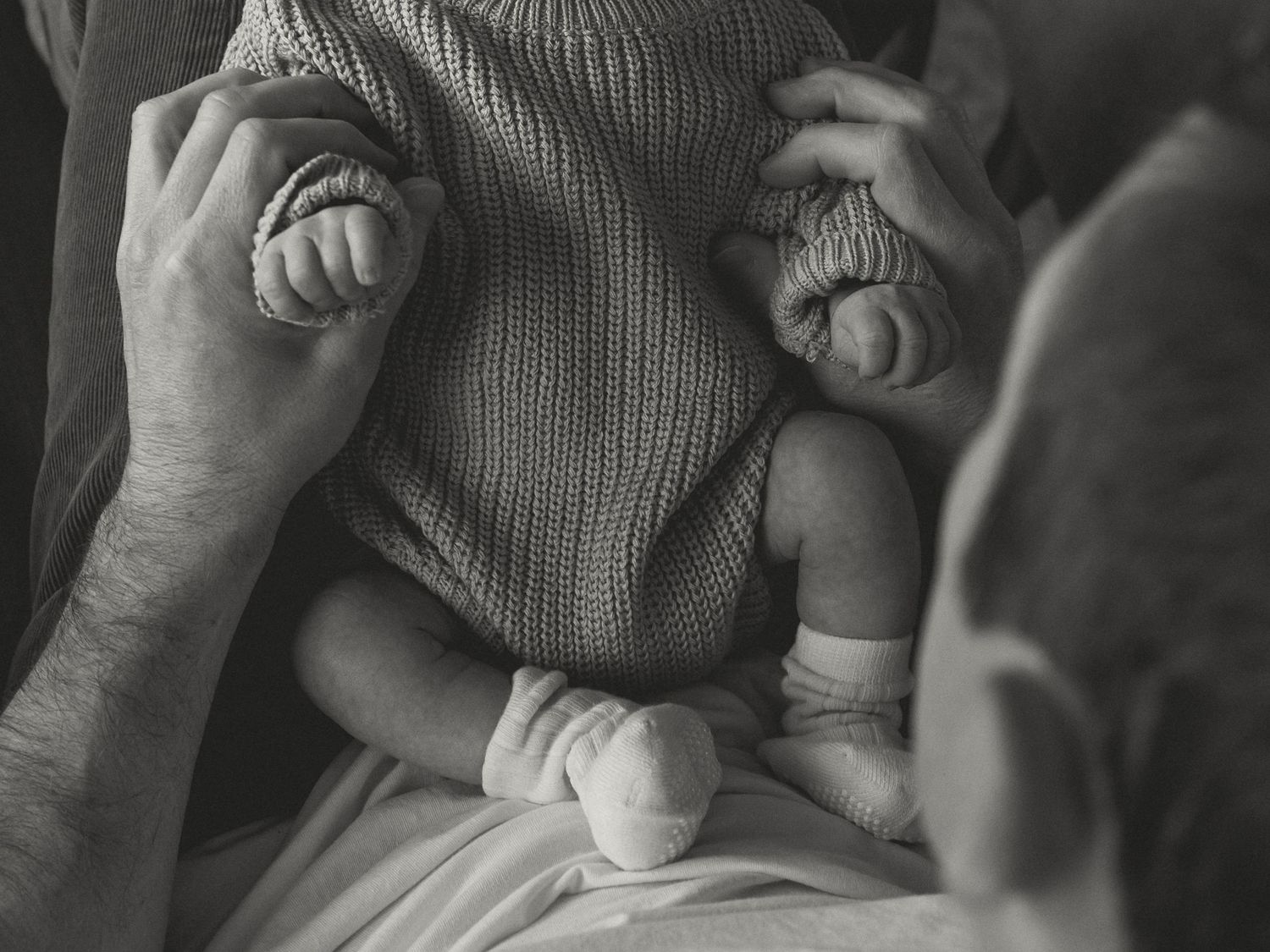 Atmospheric black and white image capturing tender moment between parent and child.