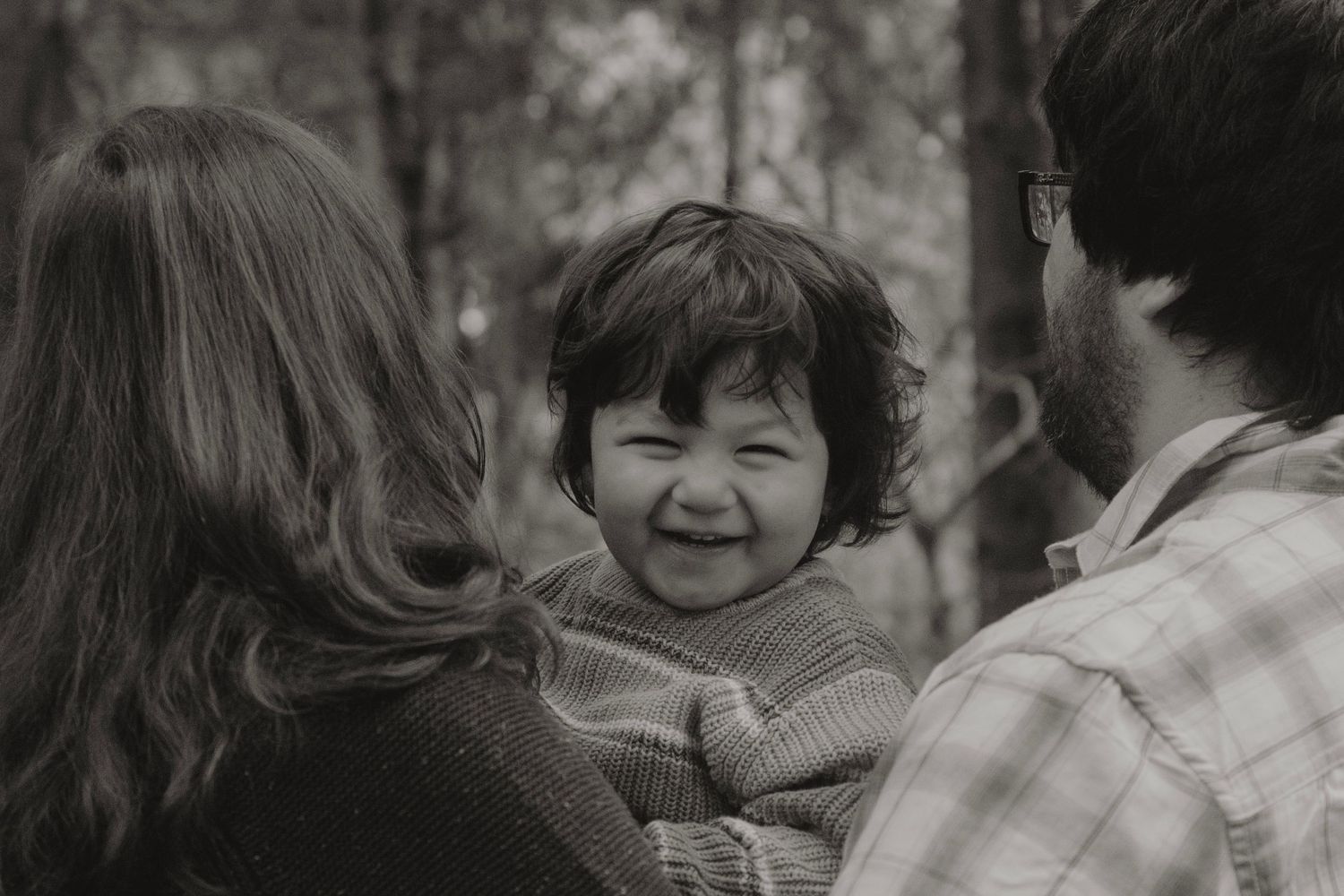 Family sharing joyful moments together in black and white photography.