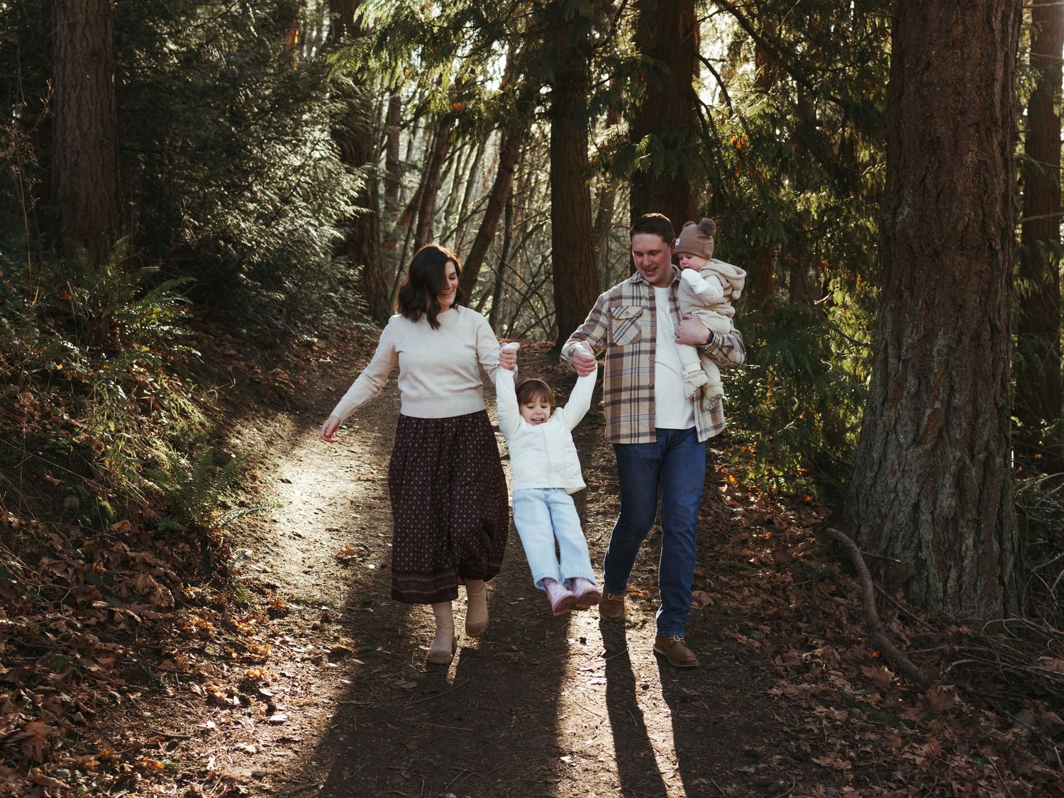 People walking together on a nature trail with dramatic backlighting through trees.