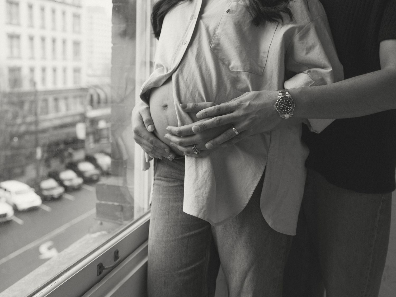 Urban studio photography session with natural window light and city views in background.
