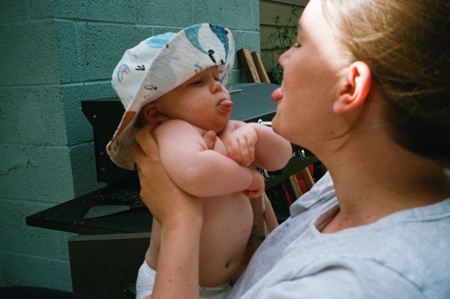 Tender close-up moments between parent and baby in soft lighting.