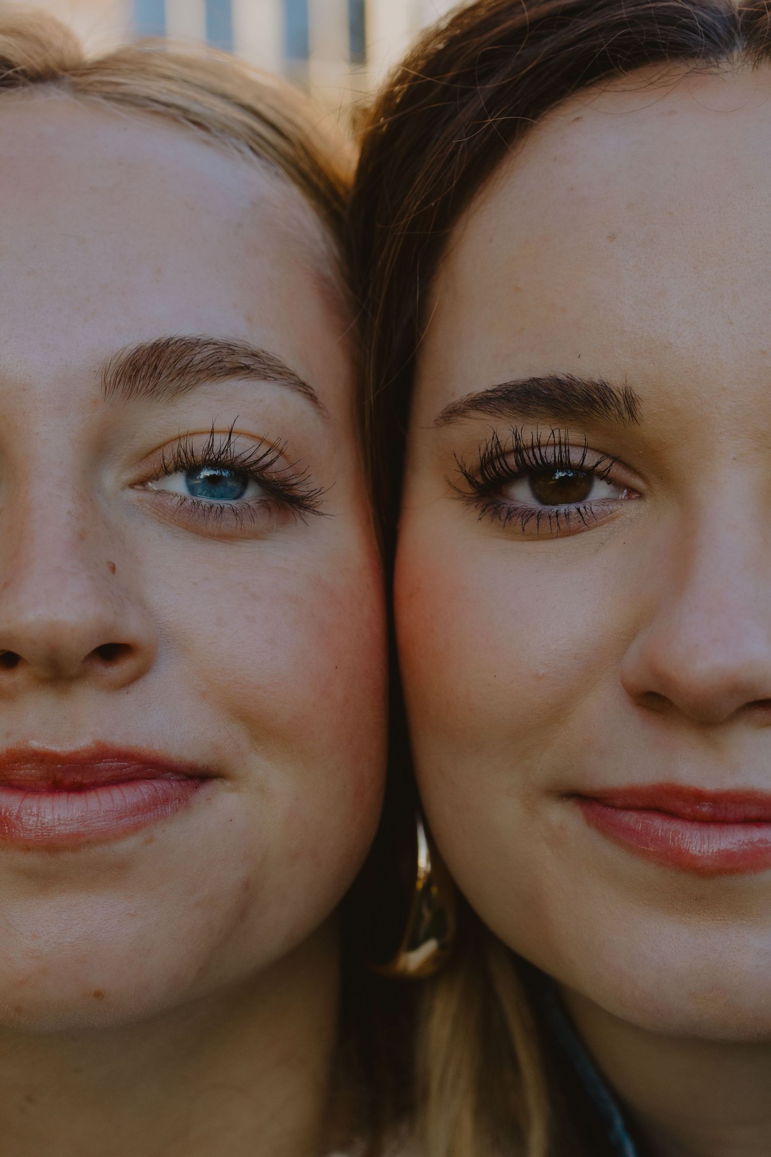 Close-up portrait showing two smiling expressions in warm, natural lighting.