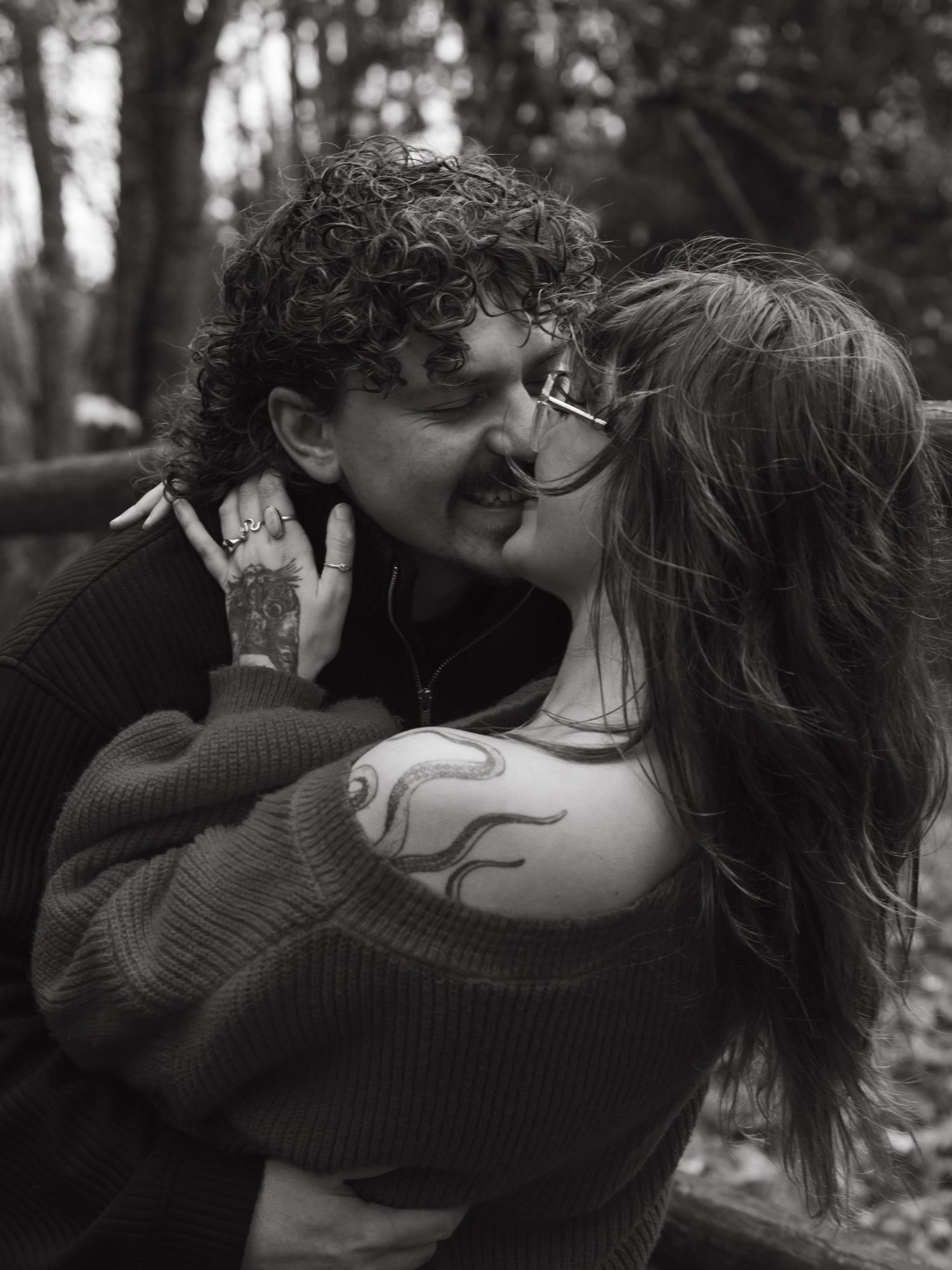 An intimate black and white portrait of a couple sharing a tender moment.