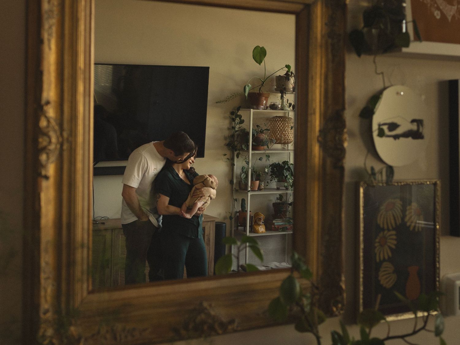 A couple's intimate moment captured through a vintage mirror with warm lighting.