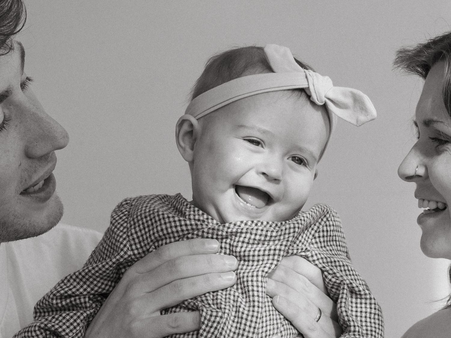 Sweet candid moment of a baby in gingham clothing.