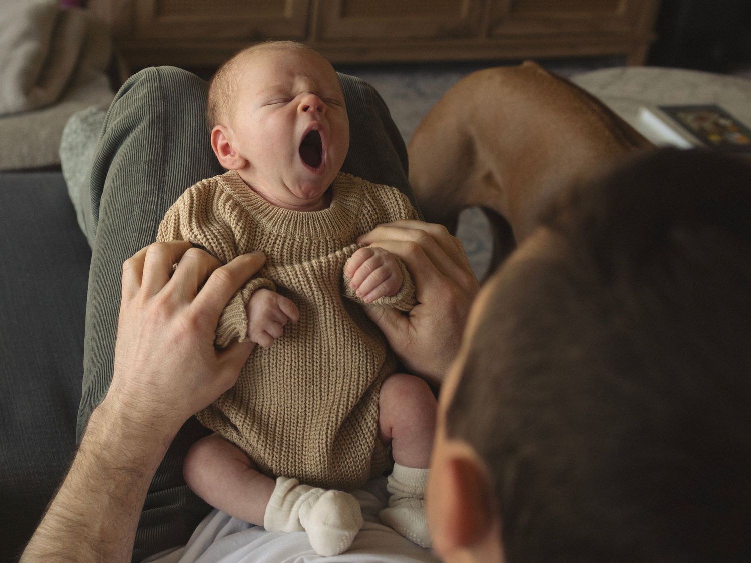 Intimate monochrome portrait showing gentle parental touch on baby's face.