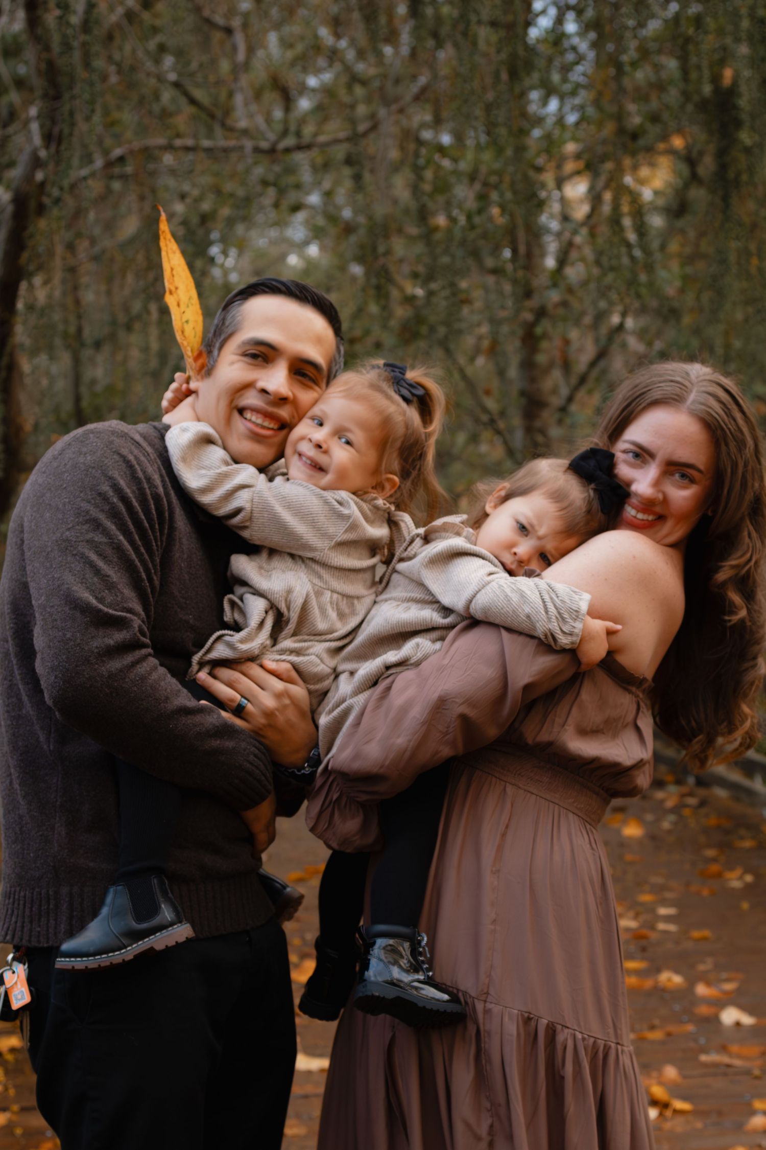 Candid family moments captured in an autumn forest setting with warm tones.