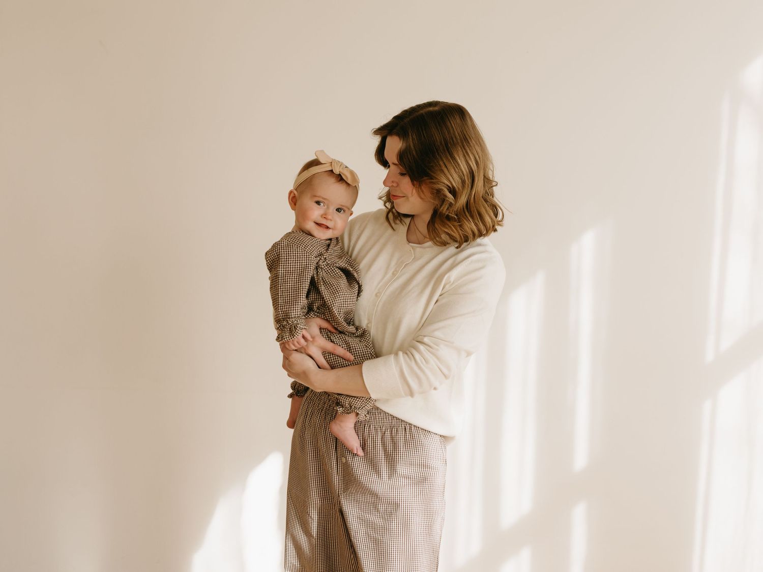 Candid family photoshoot sequence showing joyful interactions in a bright white setting.