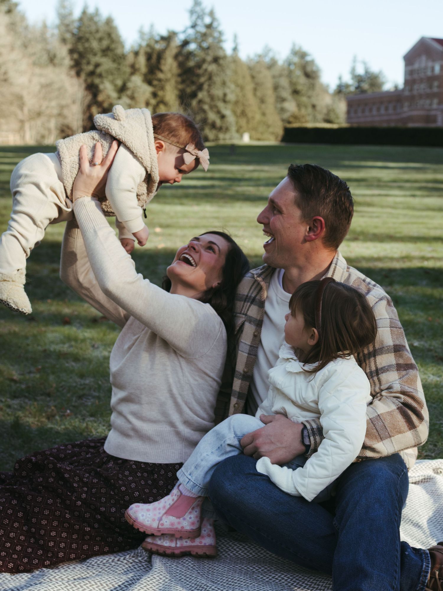 Candid moments of joy captured during a family picnic on a blanket.