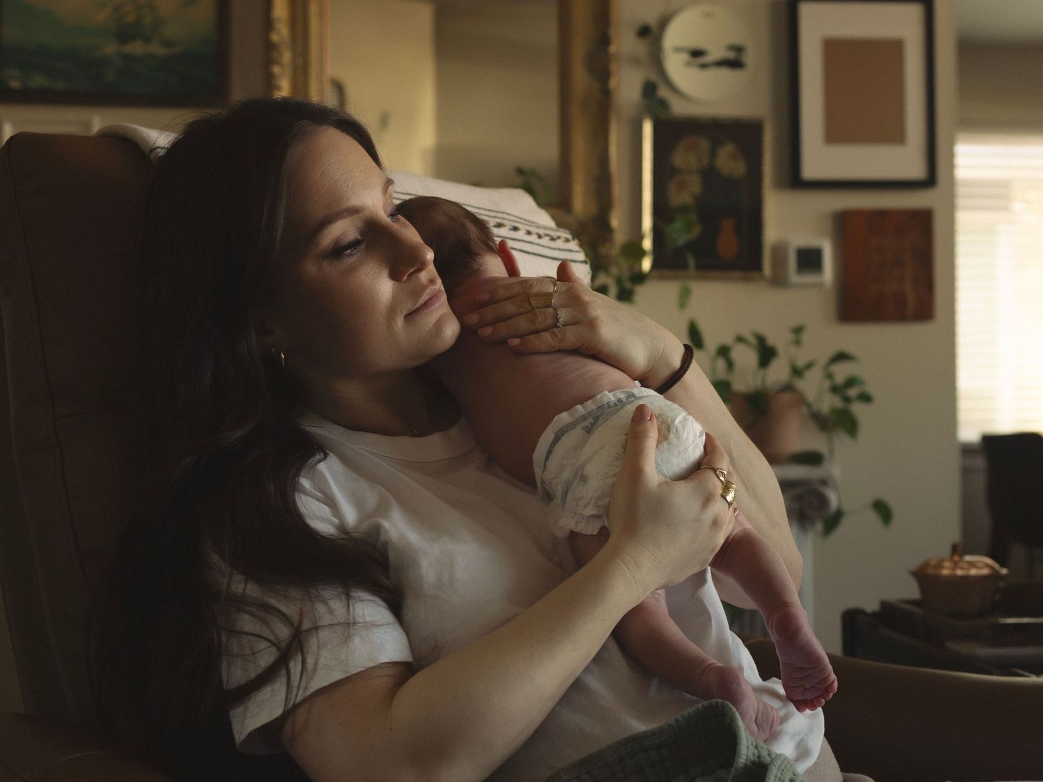 A tender moment between parent and newborn in a cozy living room setting.