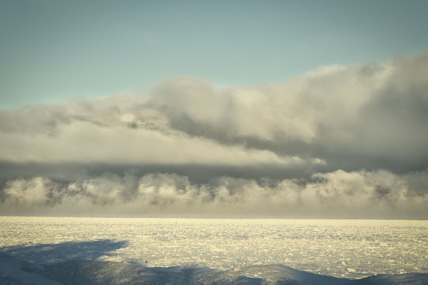 Dramatic winter clouds moving over a frozen Lake Superior in Northern Wisconsin during early morning light.