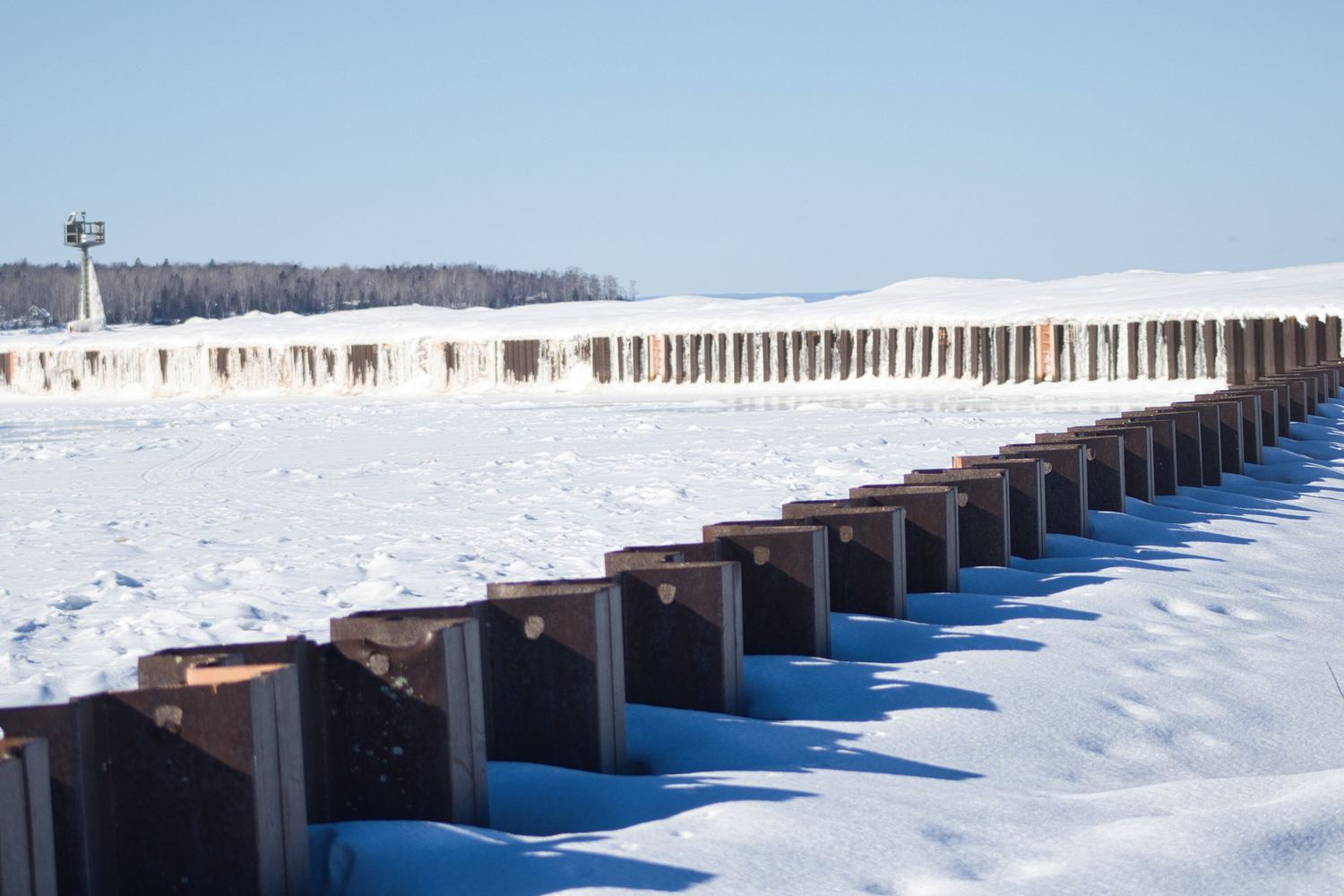 Winter snow covering a long break wall along a frozen Lake Superior in Northern Wisconsin.