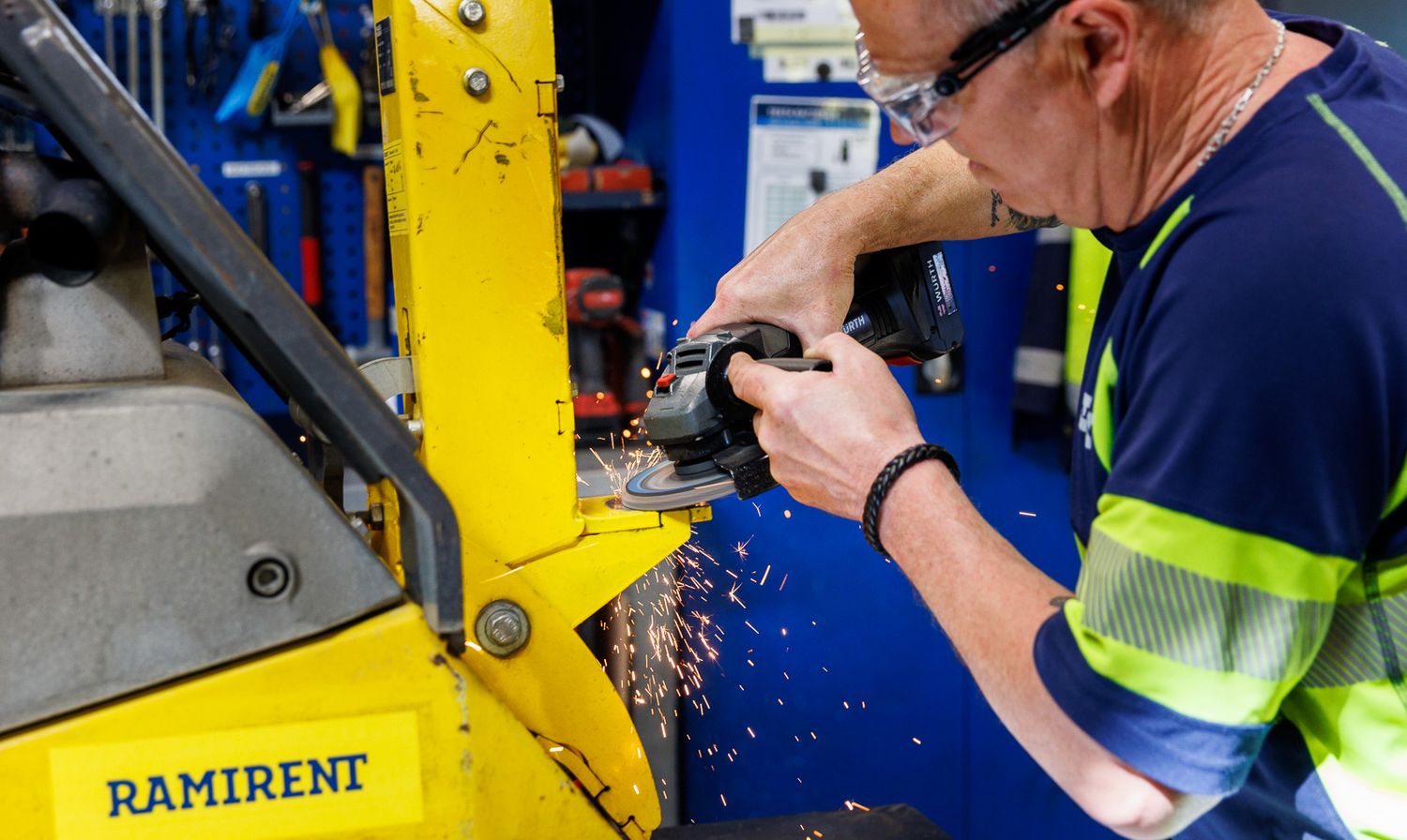 Close-up of industrial machinery maintenance with worker in safety gear.
