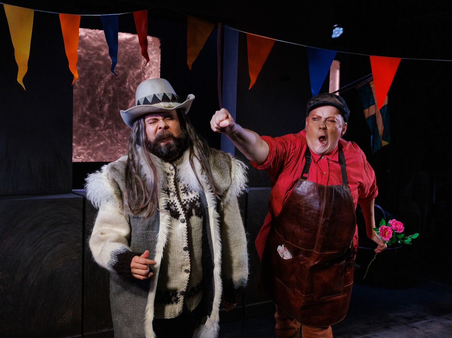 Performers in medieval-style costumes with decorative banners hanging overhead.
