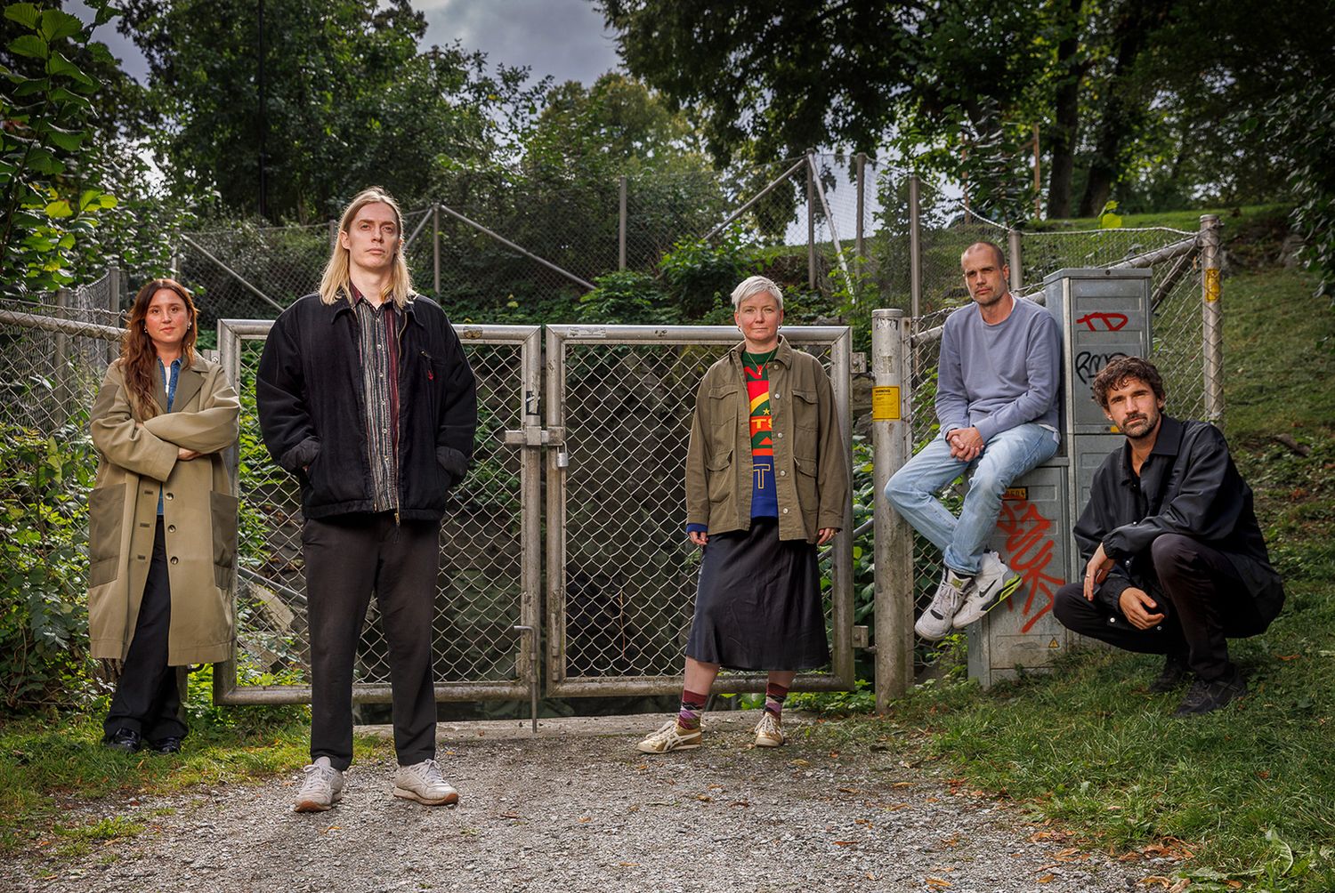 Group photo taken outdoors with trees and fence in background.