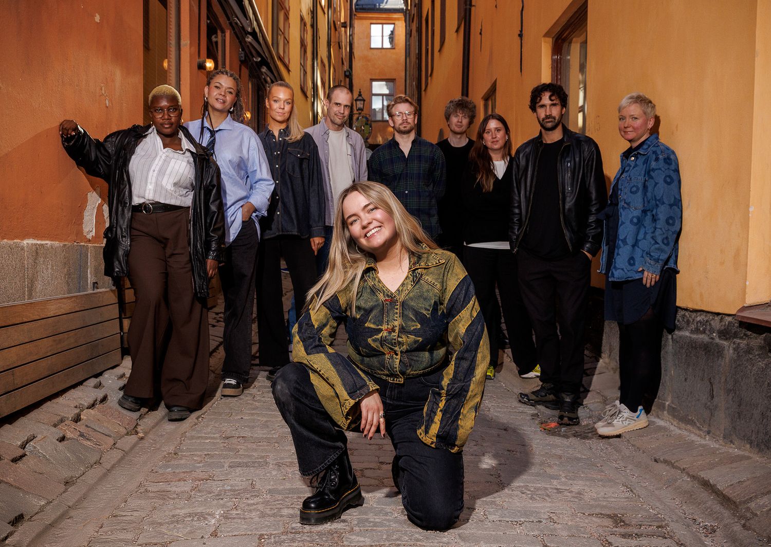Group of people gathered in a warm-lit indoor corridor.