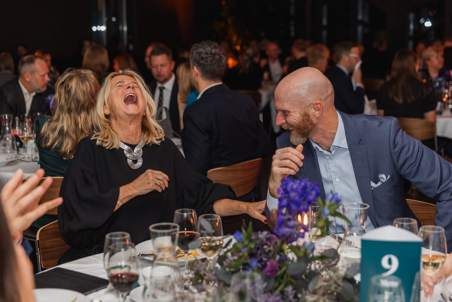 Corporate dinner event with decorated tables and attendees enjoying conversation.