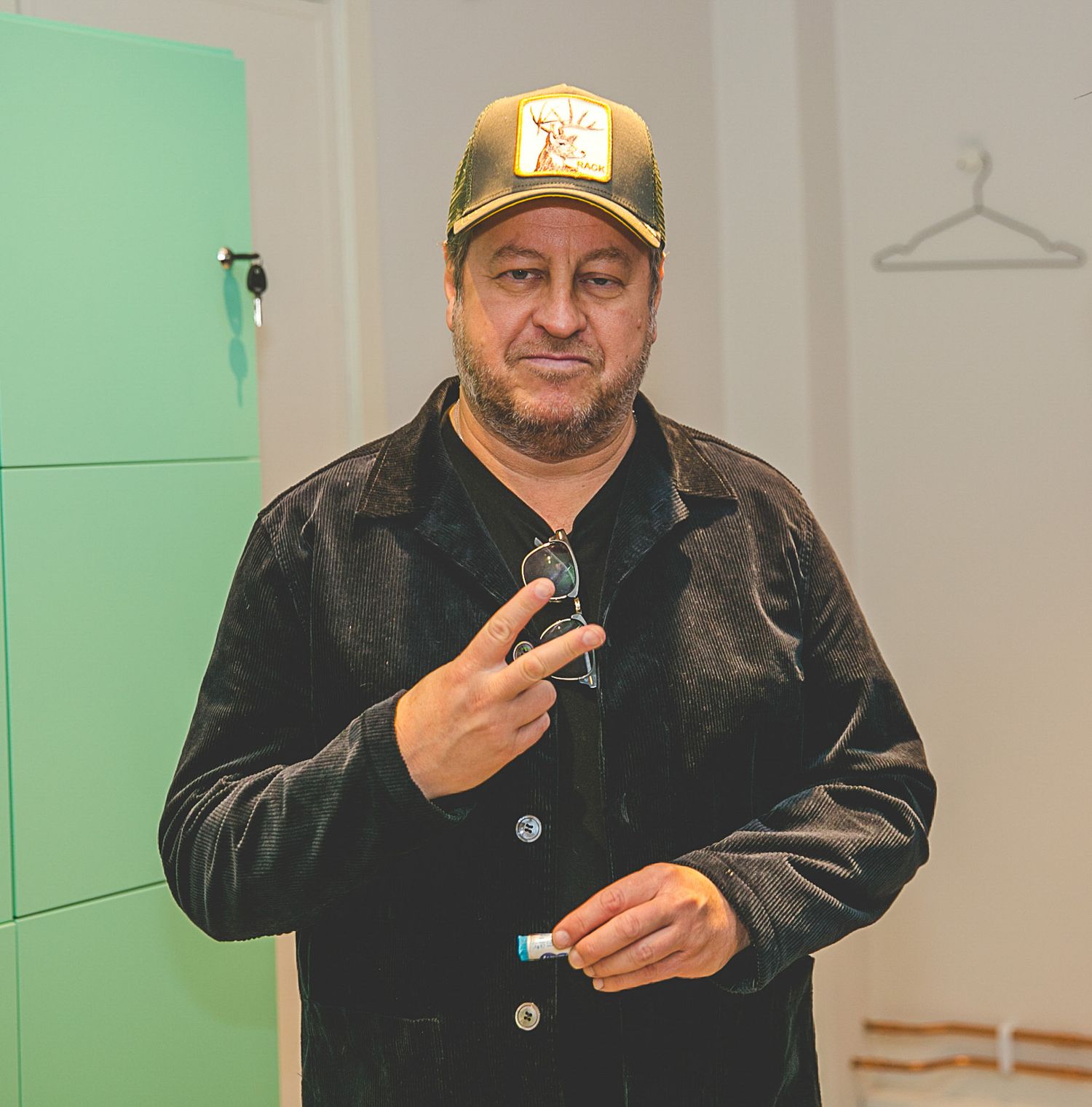 Person in baseball cap and dark jacket gesturing during a presentation.